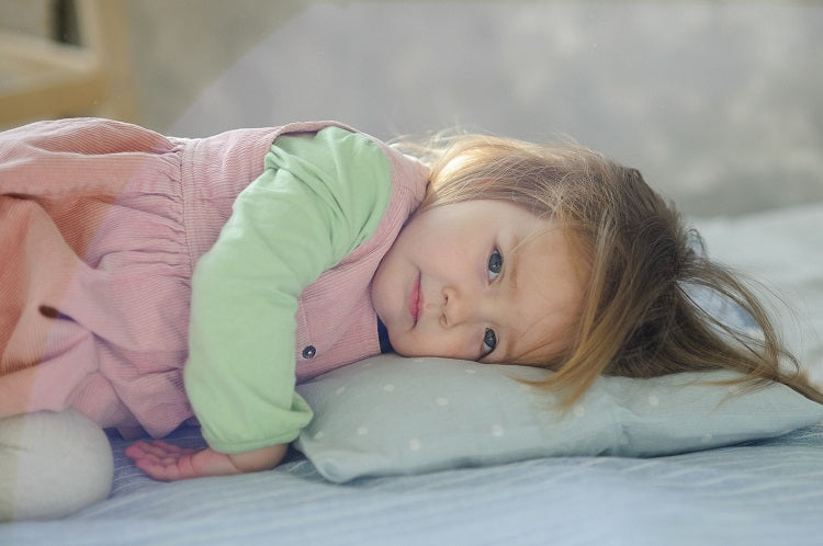 Little girl sleeping on low-loft baby pillow from A Little Pillow Company