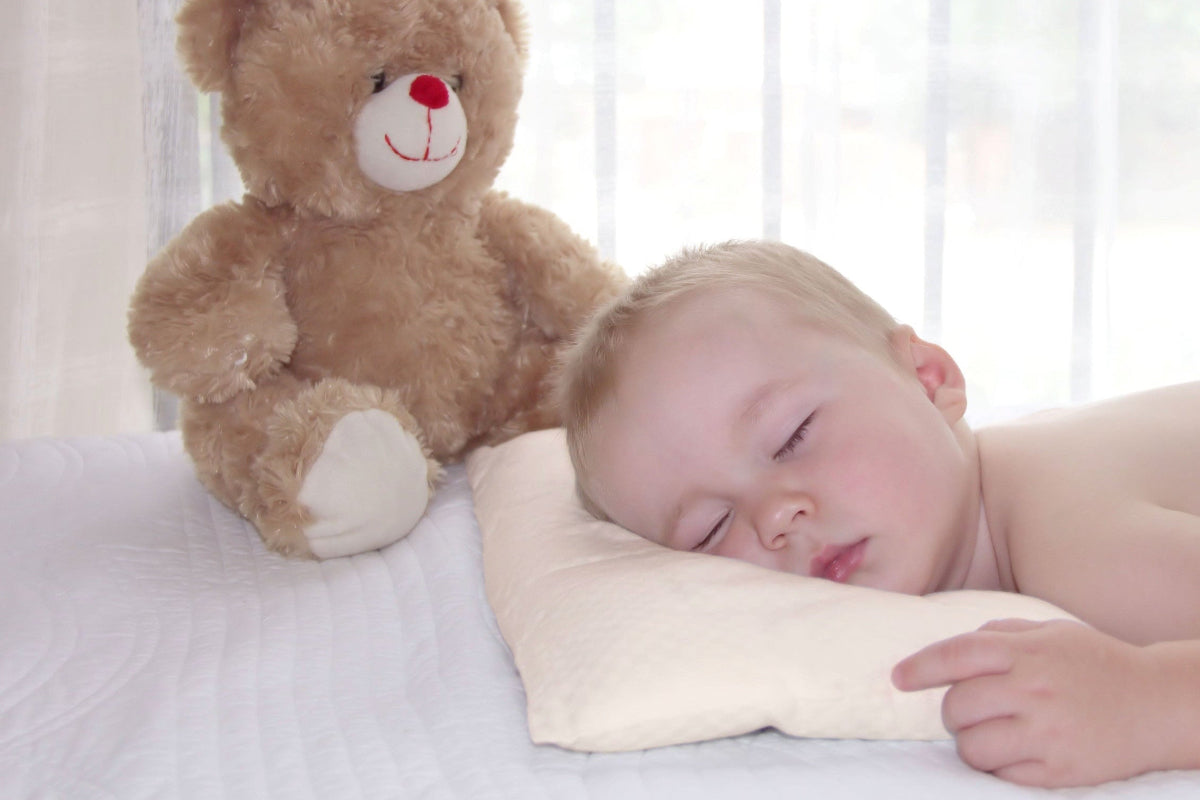 Baby stomach sleeping on a Baby's First Organic Sustainable Pillow by A Little Pillow Company