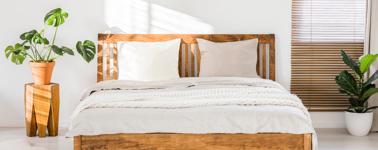 Bed with standard pillows from A Little Pillow Company in a bright room with plants